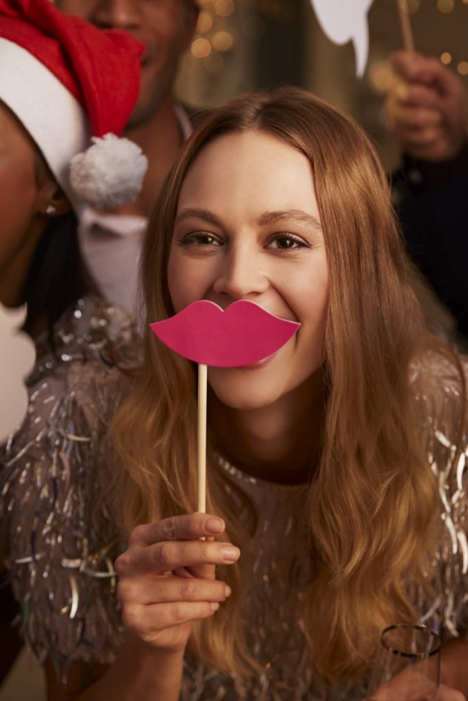 Group Of Friends Dressing Up For Christmas Party Together